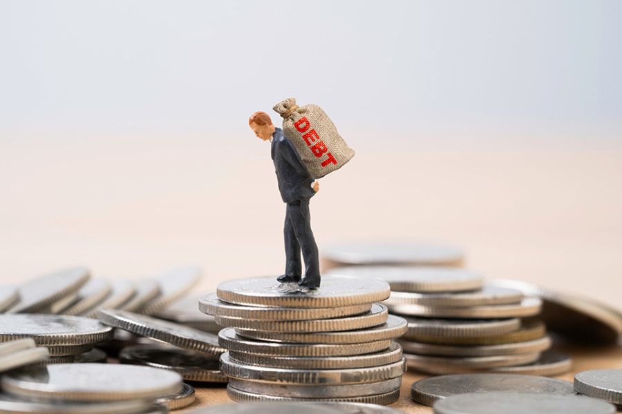 Figur mit Schuldensack auf dem Rücken